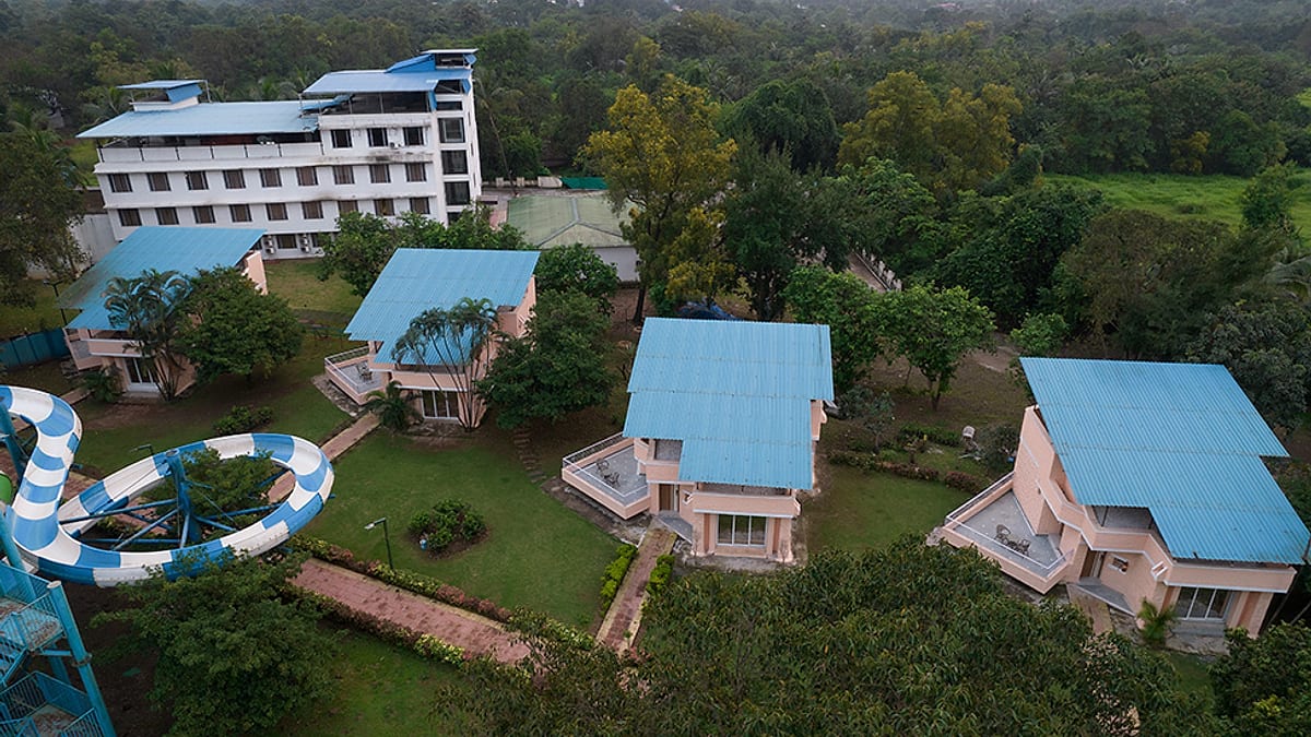 Aerial view of the resort cottages and blue water-park slides set among trees